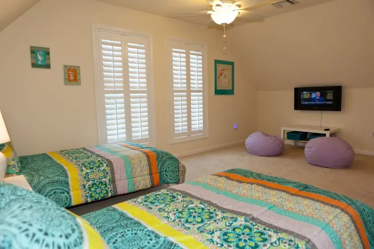 Third bedroom with two beds, TV, and beanbags, Happy Island Cottage