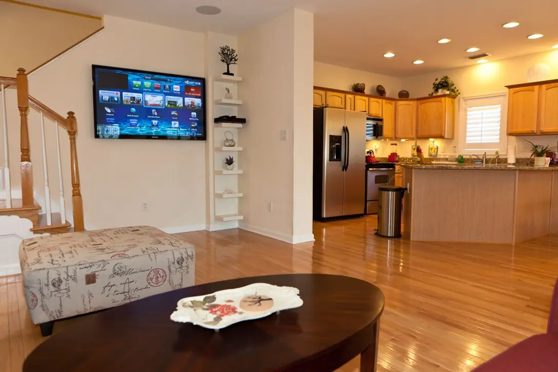 Open-plan main floor with wall-mounted TV, sitting area, and kitchen, Happy Island Cottage