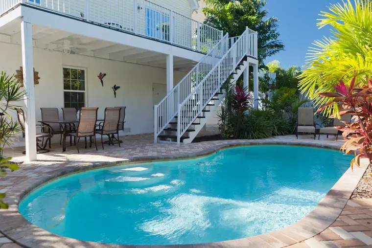 Private heated pool and paver sun deck behind Happy Island Cottage